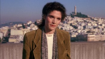 Movie still from “Class Action” (1991), directed by Michael Apted – A woman wearing a brown jacket standing in front of a city; Close Up shot, High angle