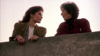 Movie still from “Class Action” (1991), directed by Michael Apted – Two women standing next to each other near a wall; Medium shot, Low angle