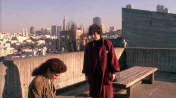 Movie still from “Class Action” (1991), directed by Michael Apted – Two women standing on a rooftop with a city skyline in the background; Wide shot, High angle