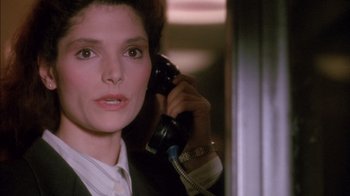 Movie still from “Class Action” (1991), directed by Michael Apted – A woman talking on a phone while wearing a suit; Close Up shot, High angle