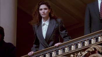 Movie still from “Class Action” (1991), directed by Michael Apted – A woman in a suit standing on top of a railing; Medium shot, Low angle