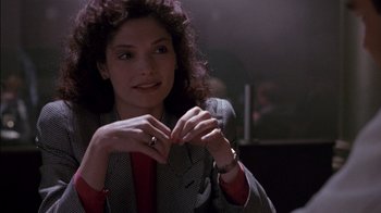 Movie still from “Class Action” (1991), directed by Michael Apted – A woman sitting in front of a microphone; Close Up shot, Over the shoulder angle