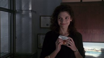 Movie still from “Class Action” (1991), directed by Michael Apted – A woman is holding a donut in her hands; Close Up shot, Over the shoulder angle