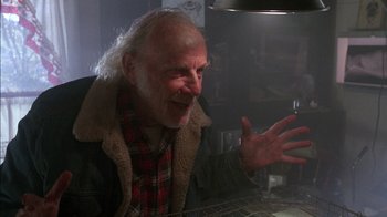 Movie still from “Class Action” (1991), directed by Michael Apted – An older man is smiling and holding his hand out; Close Up shot, Low angle