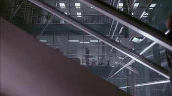 A person is standing in a room looking out a window