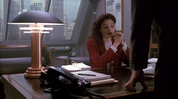 Movie still from “Class Action” (1991), directed by Michael Apted – A woman sitting at a desk in front of a phone; Medium shot, High angle