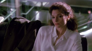 Movie still from “Class Action” (1991), directed by Michael Apted – A woman in a white shirt is sitting down; Close Up shot, Low angle