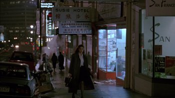 Movie still from “Class Action” (1991), directed by Michael Apted – A woman walking down the street holding a purse; Wide shot, High angle