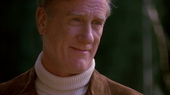 Movie still from “Class Action” (1991), directed by Michael Apted – An older man wearing a brown jacket and a white sweater; Close Up shot, Over the shoulder angle
