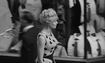 Movie still from “Cléo from 5 to 7” (1962), directed by Agnès Varda – A black and white photo of a woman in a polka dot dress; Medium shot, High angle