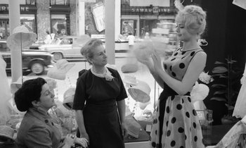 Movie still from “Cléo from 5 to 7” (1962), directed by Agnès Varda – Two women are talking to each other in front of a store window; Medium shot, Low angle