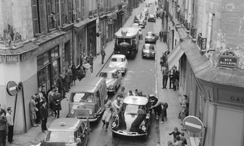 Movie still from “Cléo from 5 to 7” (1962), directed by Agnès Varda – A black and white photo of a busy city street; Extreme Wide shot, High angle