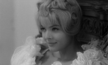 Movie still from “Cléo from 5 to 7” (1962), directed by Agnès Varda – A black and white photo of a woman with a flower in her hair; Close Up shot, High angle