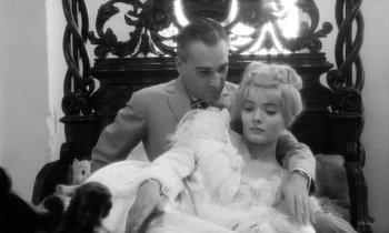 Movie still from “Cléo from 5 to 7” (1962), directed by Agnès Varda – A black and white photo of a man and a woman; Medium shot, High angle