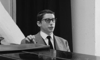 Movie still from “Cléo from 5 to 7” (1962), directed by Agnès Varda – A man in a suit and tie standing next to a piano; Close Up shot, Low angle