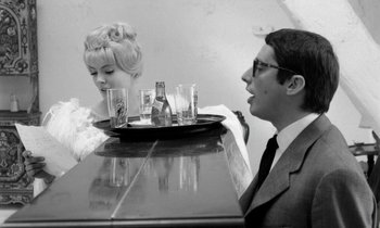 Movie still from “Cléo from 5 to 7” (1962), directed by Agnès Varda – A man and a woman sitting at a table with drinks; Medium shot, Over the shoulder angle