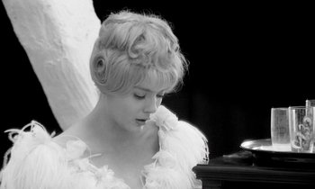 Movie still from “Cléo from 5 to 7” (1962), directed by Agnès Varda – A black - and - white photo of a woman in a white dress; Close Up shot, Low angle