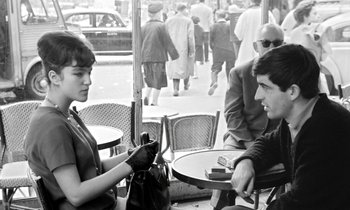Movie still from “Cléo from 5 to 7” (1962), directed by Agnès Varda – A man and a woman sitting at an outdoor table; Medium shot, Over the shoulder angle
