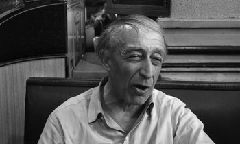 Movie still from “Cléo from 5 to 7” (1962), directed by Agnès Varda – An older man sitting in front of a staircase; Close Up shot, Over the shoulder angle