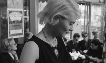 Movie still from “Cléo from 5 to 7” (1962), directed by Agnès Varda – A black and white photo of a woman in a black dress; Close Up shot, Over the shoulder angle
