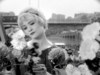 Movie still from “Cléo from 5 to 7” (1962), directed by Agnès Varda – Black and white photograph of a woman holding a vase of flowers; Close Up shot, High angle