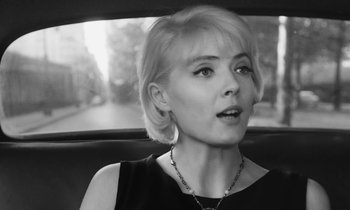 Movie still from “Cléo from 5 to 7” (1962), directed by Agnès Varda – A woman sitting in the back seat of a car; Close Up shot, Over the shoulder angle