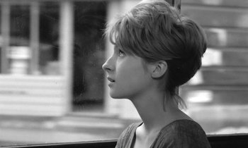 Movie still from “Cléo from 5 to 7” (1962), directed by Agnès Varda – Black and white photograph of a woman looking out a window; Close Up shot, Over the shoulder angle