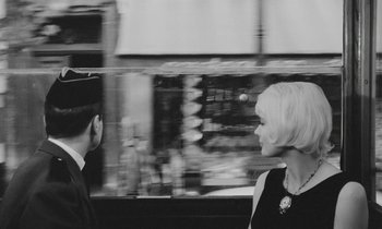 Movie still from “Cléo from 5 to 7” (1962), directed by Agnès Varda – A man and a woman standing next to each other on a street; Close Up shot, Over the shoulder angle