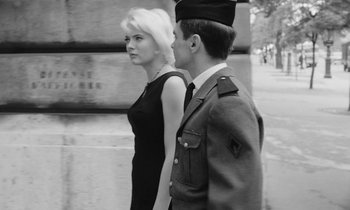 Movie still from “Cléo from 5 to 7” (1962), directed by Agnès Varda – A man and a woman in a black dress; Medium shot, Low angle