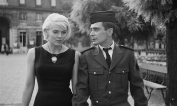 Movie still from “Cléo from 5 to 7” (1962), directed by Agnès Varda – A man and a woman are walking together; Medium shot, Low angle