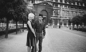 Movie still from “Cléo from 5 to 7” (1962), directed by Agnès Varda – A man and a woman standing next to each other on the sidewalk; Medium shot, High angle