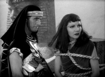 Movie still from “Cleopatra” (1934), directed by Cecil B. DeMille – A man and a woman are tied to a rope; Medium shot, High angle