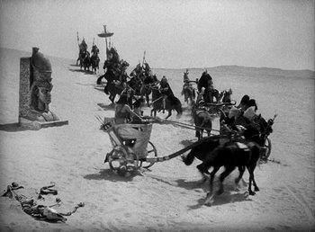 Movie still from “Cleopatra” (1934), directed by Cecil B. DeMille – A black and white photo of a group of people on horses; Extreme Wide shot, High angle