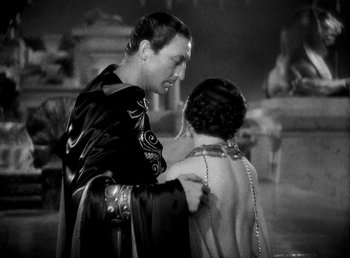 Movie still from “Cleopatra” (1934), directed by Cecil B. DeMille – A man and a woman in ancient roman garb standing next to each other; Medium shot, High angle