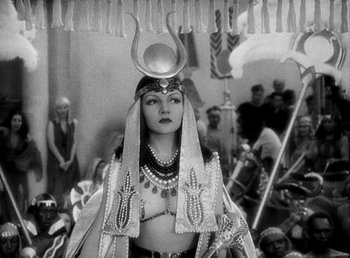 Movie still from “Cleopatra” (1934), directed by Cecil B. DeMille – A woman dressed as a egyptian queen in a movie scene; Medium shot, High angle