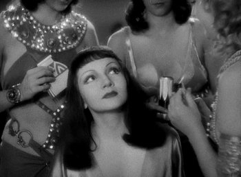Movie still from “Cleopatra” (1934), directed by Cecil B. DeMille – A black - and - white photo of a woman in front of other women; Close Up shot, Over the shoulder angle