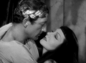 Movie still from “Cleopatra” (1934), directed by Cecil B. DeMille – A man and a woman embracing each other in a black and white photo; Close Up shot, High angle