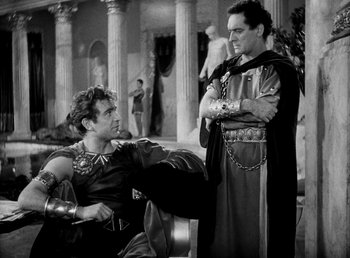 Movie still from “Cleopatra” (1934), directed by Cecil B. DeMille – Two men dressed in roman garb in front of columns; Medium shot, High angle