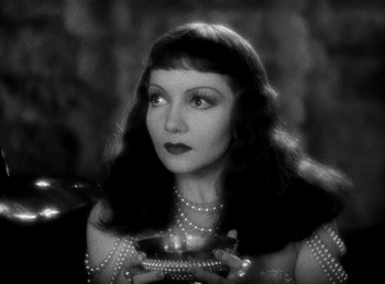 Movie still from “Cleopatra” (1934), directed by Cecil B. DeMille – A black - and - white photo of a woman holding a bowl; Close Up shot, High angle