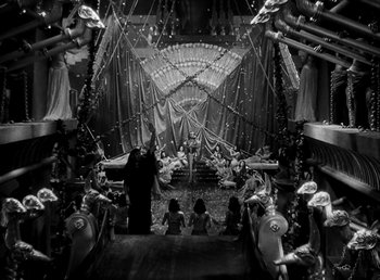Movie still from “Cleopatra” (1934), directed by Cecil B. DeMille – A black and white photo of people sitting in an auditorium; Extreme Wide shot, High angle