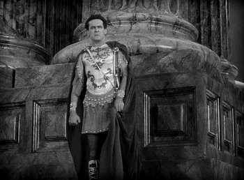 Movie still from “Cleopatra” (1934), directed by Cecil B. DeMille – A man dressed as a roman soldier standing in front of a building; Wide shot, High angle
