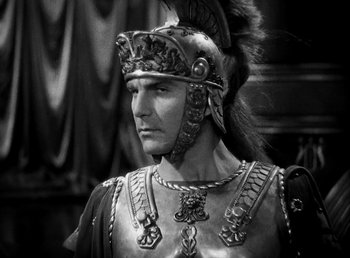 Movie still from “Cleopatra” (1934), directed by Cecil B. DeMille – Black and white photograph of a man in a roman soldier costume; Close Up shot, High angle