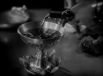 Movie still from “Cleopatra” (1934), directed by Cecil B. DeMille – A black and white photo of a person pouring water into a bowl; Extreme Close Up shot, High angle