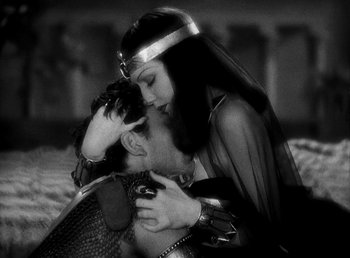 Movie still from “Cleopatra” (1934), directed by Cecil B. DeMille – A man and a woman kissing on a bed; Medium shot, High angle