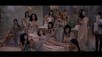 Movie still from “Cleopatra” (1963), directed by Rouben Mamoulian – A group of women standing next to each other in a room; Wide shot, High angle