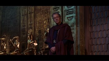 Movie still from “Cleopatra” (1963), directed by Rouben Mamoulian – A man in a robe standing in front of a wall; Medium shot, Low angle