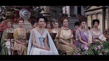 Movie still from “Cleopatra” (1963), directed by Rouben Mamoulian – A group of women sitting in a row in front of a building; Medium shot, High angle