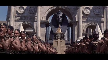 Movie still from “Cleopatra” (1963), directed by Rouben Mamoulian – A group of men standing next to each other in front of a building; Extreme Wide shot, High angle
