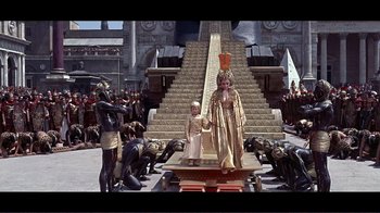 Movie still from “Cleopatra” (1963), directed by Rouben Mamoulian – A man and a child are standing in front of a crowd; Extreme Wide shot, High angle