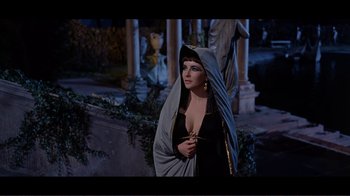 Movie still from “Cleopatra” (1963), directed by Rouben Mamoulian – A woman dressed in black and holding a staff; Medium shot, Over the shoulder angle